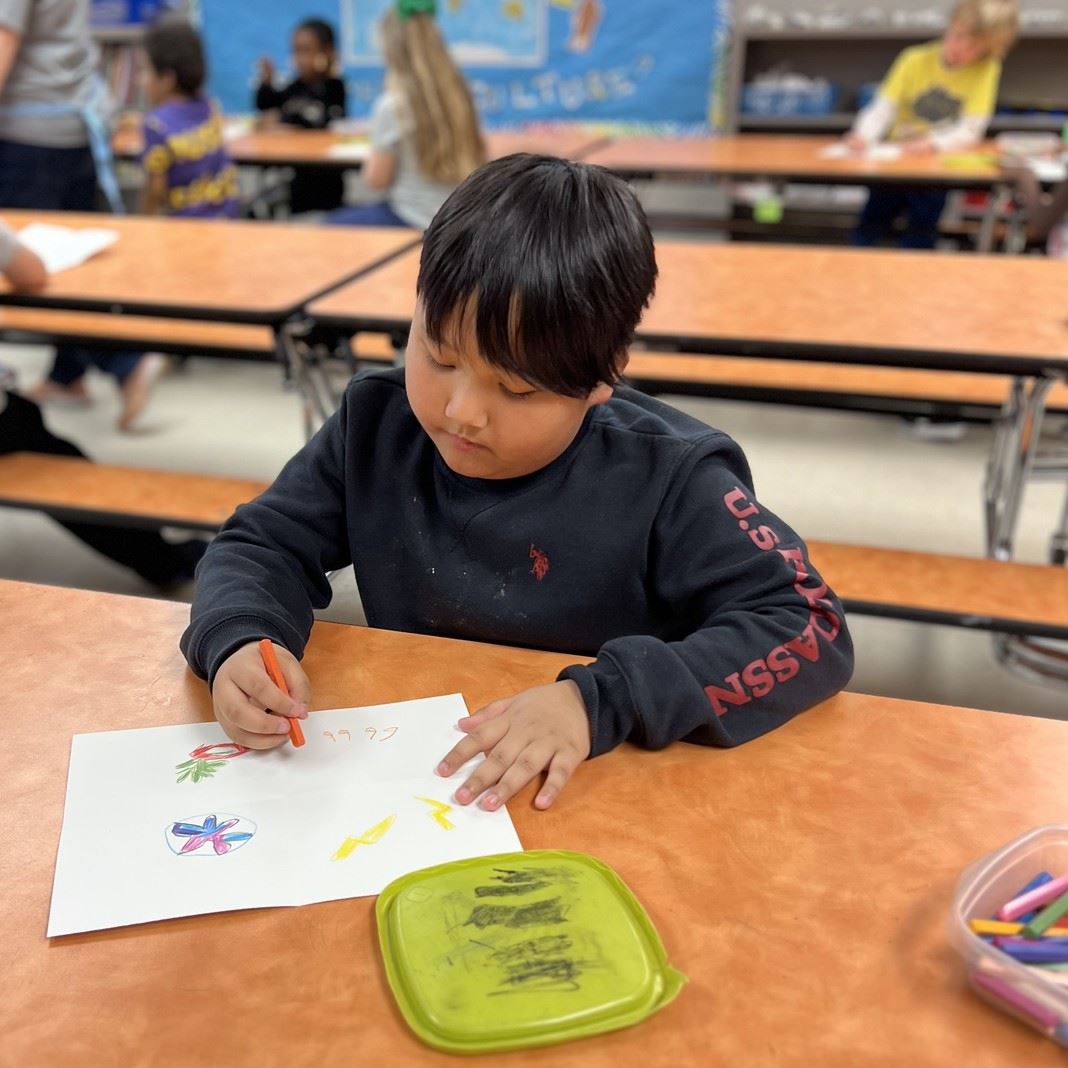  A student works on artwork on a desk
